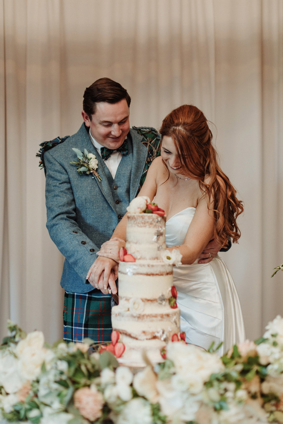 Bride and groom cut their tiered wedding cake at Dean Banks at The Pompadour